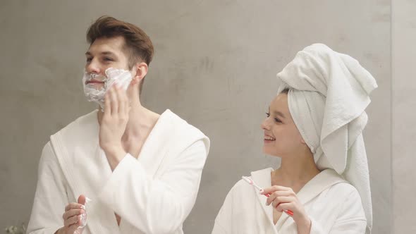 Excited Happy Caucasian Couple Doing Daily Morning Procedures in Bathroom
