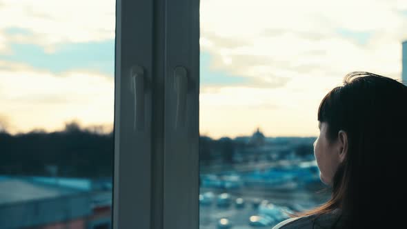 Woman Looking Out the Window in the Evening at Sunset Moving Camera Cinematic Shot