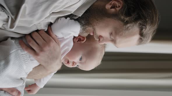 Vertical View Closeup Father Bearded Dad Holding Little Daughter Son Child Newborn Infant in Looking alt