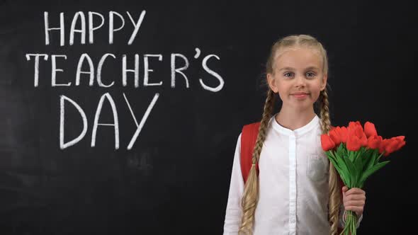 Happy Teachers Day Written on Blackboard, Schoolgirl Holding Bunch of Tulips alt