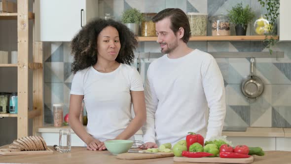 Mixed Race Couple Discussing in Kitchen alt