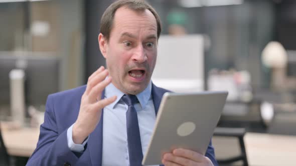 Portrait of Businessman Having Loss on Tablet in Office alt