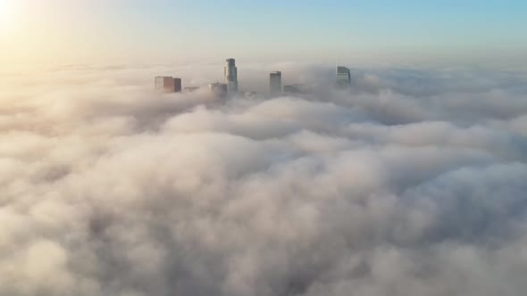 Aerial of the downtown Los Angeles surrounded by clouds alt