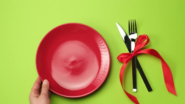 red round plate, knife with fork and Christmas decor  alt