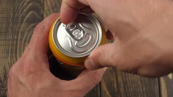 Male opening unmarked soda can of fizzy cola close up
