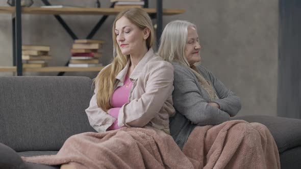 Argued Senior Women Sitting Back to Back on Couch Sighing Thinking alt