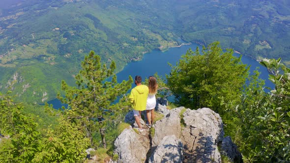 Aerial View on Couple Standing Against Amazing Nature View on Mountain Lake in on the Border of alt