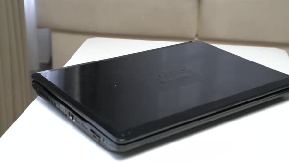a black laptop on a white table alt