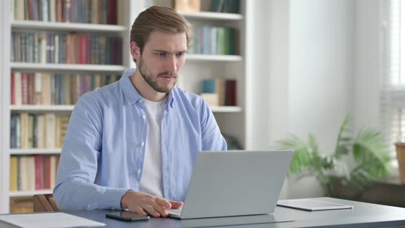 Man Reacting to Loss While Using Laptop alt