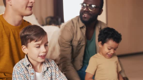 Multi-ethnic friends and their children playing video games