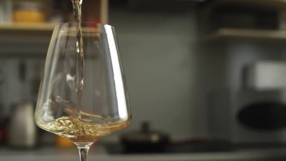 White wine is Poured into Transparent Glass The camera Moves Around the Table in the kitchen alt