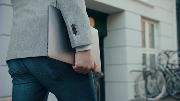 Korean Businessman Carrying Laptop In Street alt