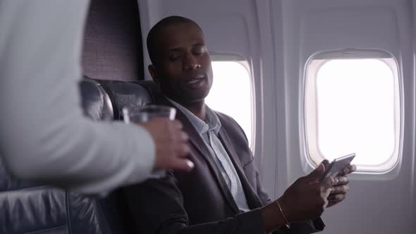 Businessman using digital tablet on airplane