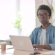Young African Man Smiling at Camera While Using Laptop in Office - VideoHive Item for Sale