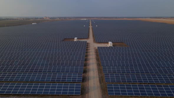 Aerial Drone View Into Large Solar Panels at a Solar Farm at Early Spring Sunset alt