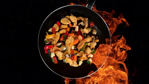 Super Slow Motion Shot of Throwing Chicken Meat Mixture on Wok Pan and Fire Blast at 1000Fps alt