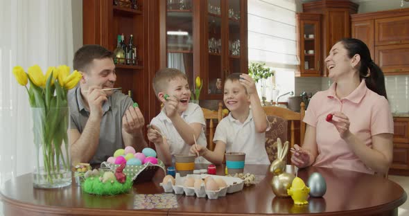 Family of 4 Members Smile Paint Eggs and Show in What Colors They Painted Eggs alt