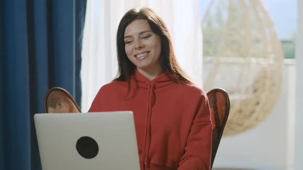 Happy brunette millennial woman making video call to her friends alt