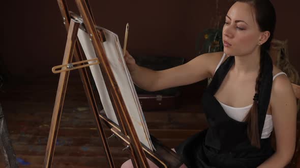 Calm Woman Painting in Light Home Studio