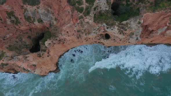 Sensational Top Down Drone Aerial View of Turquoise Water Waves Crashing Against Cliff Coast Lagos alt