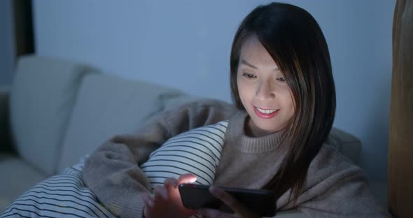 Woman check on smart phone at home in the evening alt