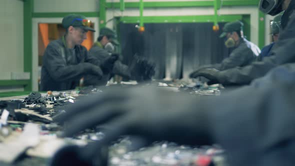 Many Workers Sort Trash on a Line alt