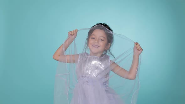 Beautiful Little Child Girl in Silver Dress Dancing on Blue Background