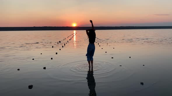 Free happy woman dancing and enjoying the sunset view. alt