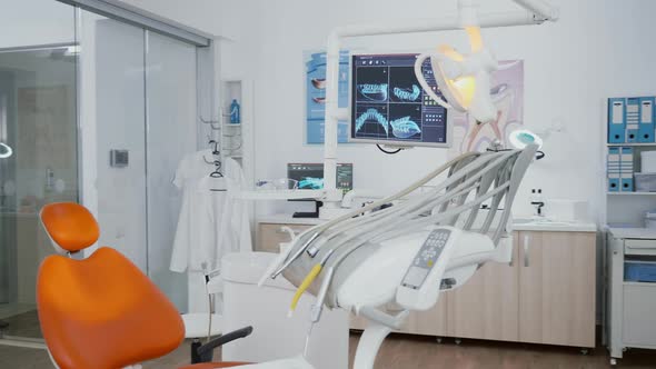 Revealing Shot of Orthodontist Chair with Nobody in Dental x Ray Images on Display alt