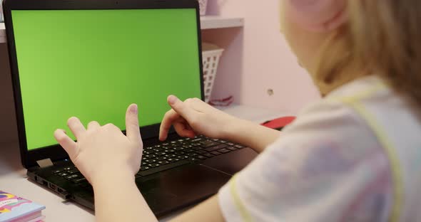 Teenage Girl Studding at Home on Laptop Computer with Green Screen at Home alt