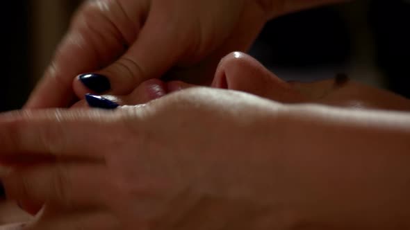 Close Up Masseuse Hands Massaging Female Face alt