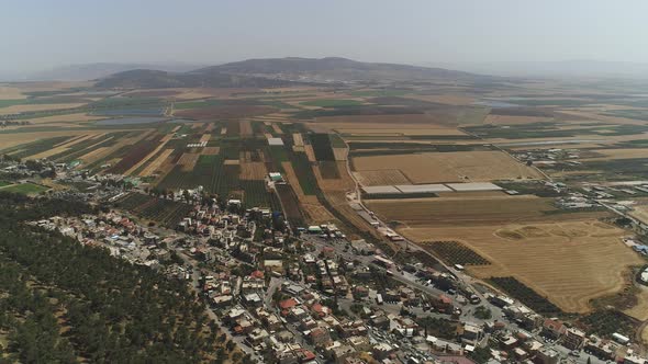 Aerial of agricultural fields and a village alt