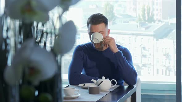 Man Drinking Tea Waiting for Someone at the Restaurant alt