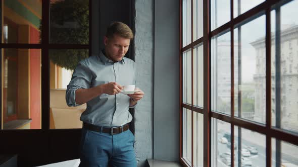 Young man with a cup of coffee in the office alt