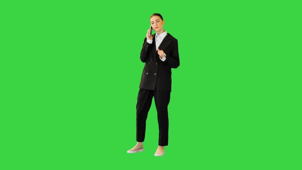 Young Female Office Worker Talking on Mobile Phone Smiling on a Green Screen Chroma Key alt