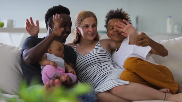 Young African Multiracial Family with Children Taking Selfie Photo on Couch in Apartment Interior alt