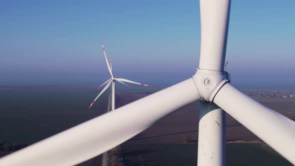 Windmills Produce Clean Energy in Field Against Blue Sky