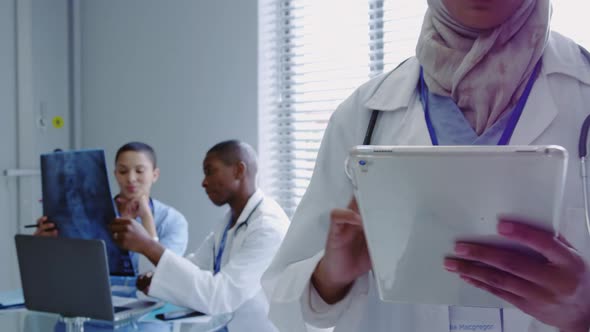 Front view of Middle-East female doctor using digital tablet in hospital alt
