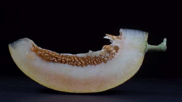 Yellow melon on a black background, close up. Rotates slice yellow melon alt