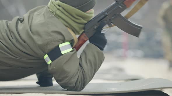 Professional Caucasian Military Woman Lying Down on Karemat and Aiming with Army Gun alt