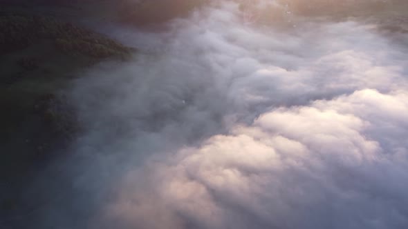 Aerial Top View of Inverse Cloud Cover in the Light of the Morning Sun Misty Landscape