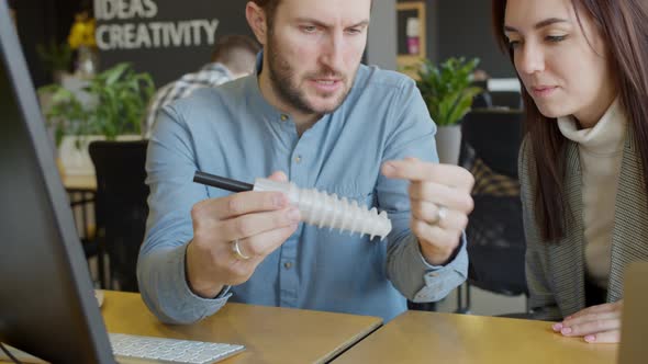 Male Engineer Showing Detail to Female Colleague