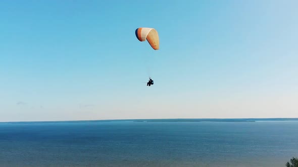 Two People Are Flying Above the Water on the Paraplane alt
