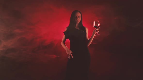 Woman with Glass of Red Wine in Red Smoke