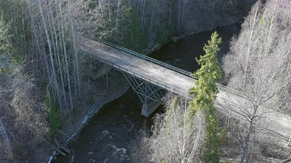 Awesome Drone Shot of a River in a Forest with a Bridge Crossing It
