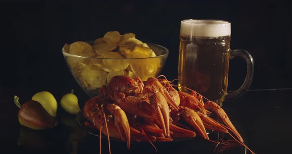 Close Up View of Man Arm Taking Lobsters with Foamy Bear Pouring in Glass and Crisp Chips on