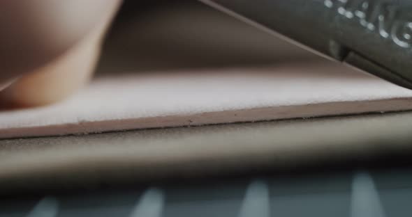 Close Up View of Tailor Cuts Leather Piece with Knife Preparing Blanks for Making Shoes Slow Motion