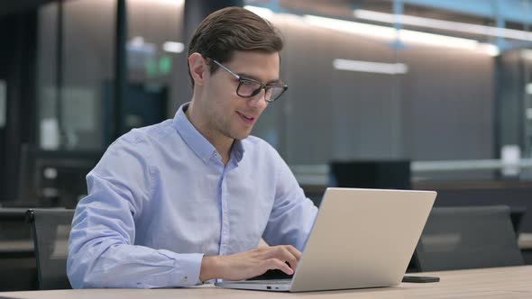 Successful Young Man Celebrating on Laptop at Work alt