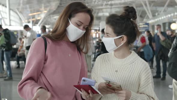 Two Women in Medical Mask Portrait Laughing and Talking in Airport Terminal Preventing Themselves alt