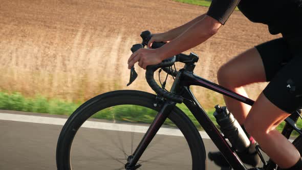 Female legs pedaling on road bicycle alt